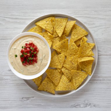 Üst görünüm, bir kase içinde ev yapımı peynirli daldırma, sarı tortilla cips. 