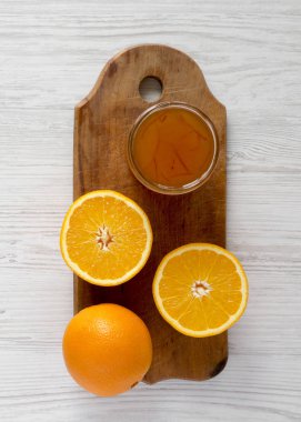 Üst görünüm, beyaz ağaçlık üzerinde rustik bir tahta üzerinde ev yapımı portakal reçeli