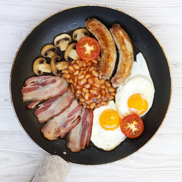 Colazione all'inglese completa in una padella con salsicce, uova fritte — Foto Stock