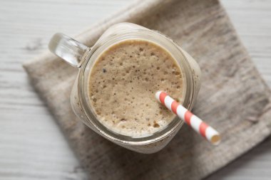 Cam kavanoz muz, kivi, beyaz wo üzerinde elma smoothie dolu