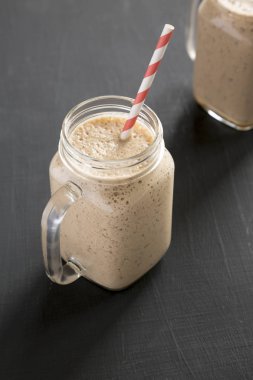 Cam kavanoz muz, kivi, siyah bir s üzerinde elma smoothie dolu