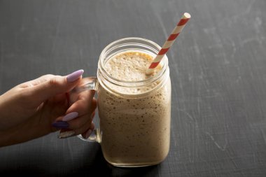 Bir kadının elinde muz dolu cam kavanoz fincanı var.