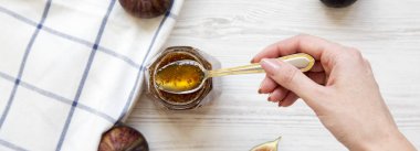 Bir kadın el incir reçeli ile bir kaşık tutar, havai görünümü. Kaynak: ab