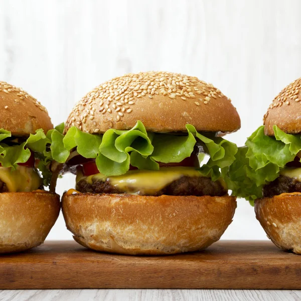 Domácí cheeseburgery na rustikální dřevěné desce, pohled z boku. Closeu — Stock fotografie