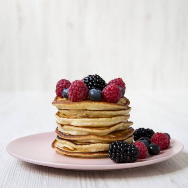 Beyaz ahşap su üzerinde pembe bir tabak üzerinde çilek ile Tatsy krep