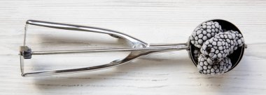 Beyaz ahşap surfac üzerinde dondurulmuş böğürtlen ile Dondurma kepçe