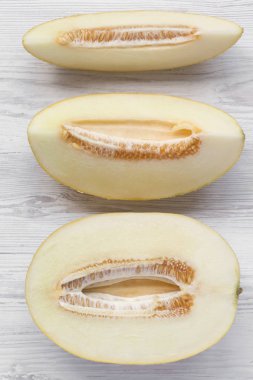 Beyaz ahşap bir yüzeyüzerinde kavun dilimleri, üst görünümü. Yukarıdan, fl