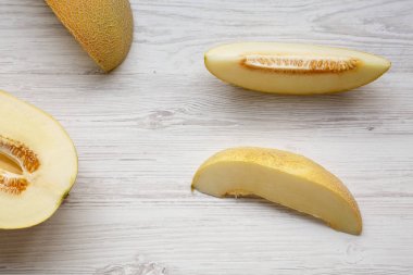 Beyaz ahşap arka plan üzerinde kavun dilimleri, üst görünümü. Yukarıdan,