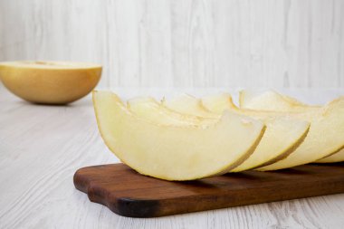 Rustik ahşap bir tahta üzerinde dilimlenmiş kavun, yan görünüm. Close. 