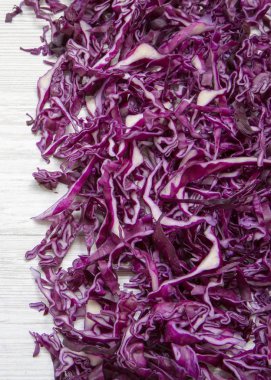 Beyaz ahşap arka plan üzerine doğranmış kırmızı lahana, yakın çekim. Sayfanın Üstü 