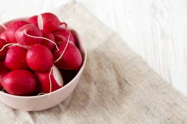 Pembe bir kapta taze kırmızı turp, yan görünüm. Kopyalama alanı.