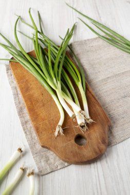 Beyaz ahşap su üzerinde rustik ahşap tahta üzerinde taze yeşil soğan