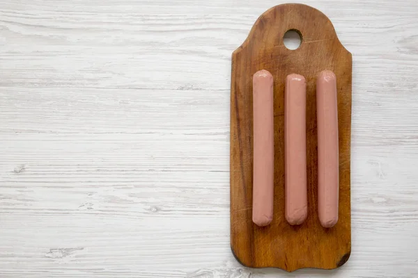 Beyaz ahşap backgr üzerinde rustik ahşap tahta üzerinde hot dog sosis — Stok fotoğraf