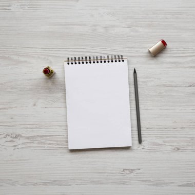 Kalem, ruj ve boş not defteri ile kadınsı çalışma alanı, üst 