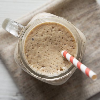 Cam kavanoz muz, kivi, beyaz wo üzerinde elma smoothie dolu