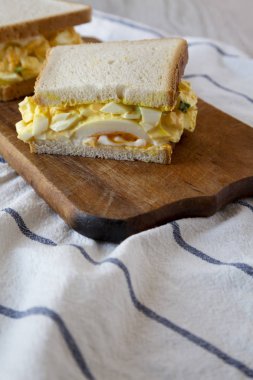 Rustik ahşap tahta üzerinde ev yapımı yumurta salatası sandviç, yan görünüm.
