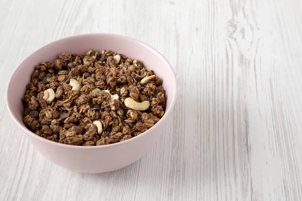 Homemade chocolate granola with nuts in a pink bowl, side view. — Stock Photo, Image