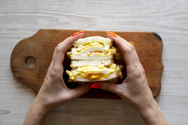 Frauenhände halten hausgemachtes Eiersalat-Sandwich in der Hand, Draufsicht. Überhaut — Stockfoto