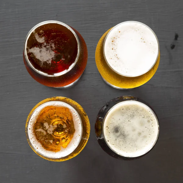 Assorted beers on a black background, top view. Overhead, from a
