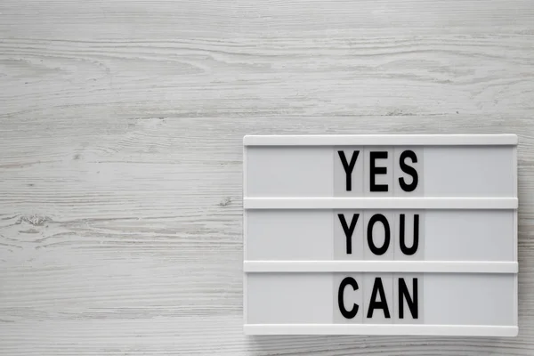 'Sí puedes' palabras en una caja de luz sobre una superficie de madera blanca, superior — Foto de Stock