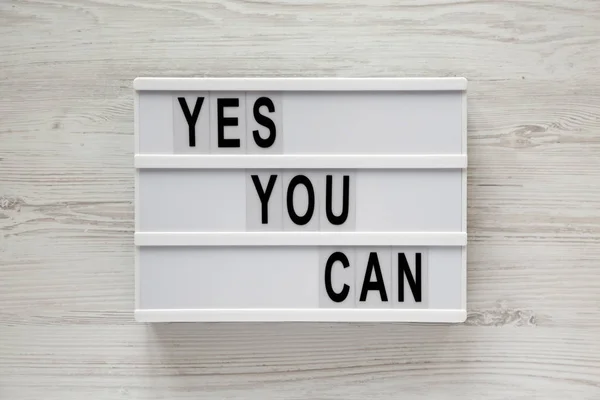 "Oui vous pouvez" mots sur une lightbox sur fond blanc en bois , — Photo