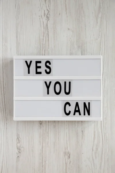 "Yes you can" Worte auf einem Leuchtkasten über weißem Holzhintergrund, — Stockfoto