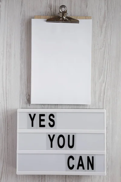 "Yes you can" Worte auf einem Leuchtkasten, Klemmbrett mit leerem Blatt — Stockfoto