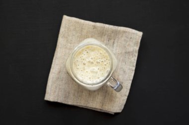 Siyah bir arka plan üzerinde bir cam kavanoz kupa muz yüzlü, üst vi