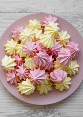 Beyaz ahşap yüzey üzerinde pembe bir plaka üzerinde Mini bezeler, üst vi