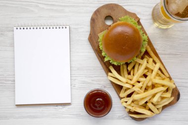 Hamburger, patates kızartması, sos, soğuk bira bardak ve boş değil