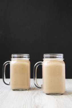 Cam kavanozsağlıklı muz elma smoothie, yan görünüm. Close