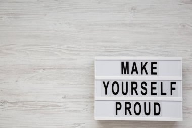 'Kendini gururlandır' sözleri beyaz bir tahta üzerinde modern bir tahtada 