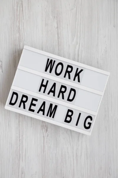 "work hard dream big" steht auf einem Leuchtkasten auf einem weißen Holzrücken — Stockfoto