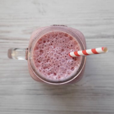 Beyaz ahşap üzerinde cam bir kavanoz kupa çilek muz smoothie 