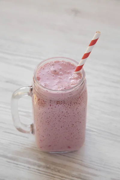 Mason tasse en verre pot rempli de smoothie à la banane fraise sur un — Photo