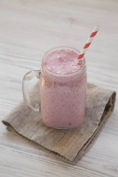 Mason tasse en verre pot rempli de smoothie à la banane fraise sur un — Photo