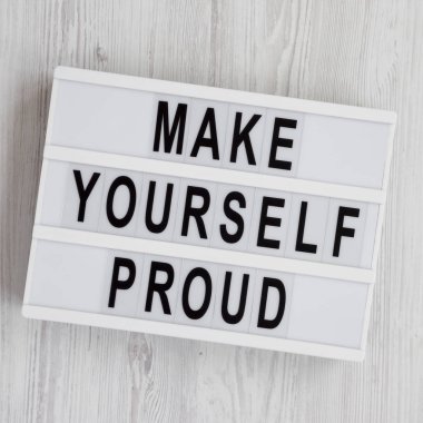 Beyaz ahşap sırt üzerinde metin 'Kendinizi gurur olun' ile ışık kutusu