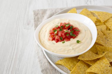 Bir kase, sarı tortilla cips, yan görünüm ev yapımı peynirli daldırma.