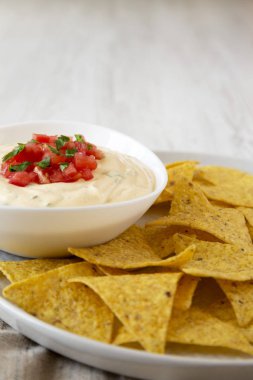 Bir kase, sarı tortilla cips, yan görünüm ev yapımı peynirli daldırma.
