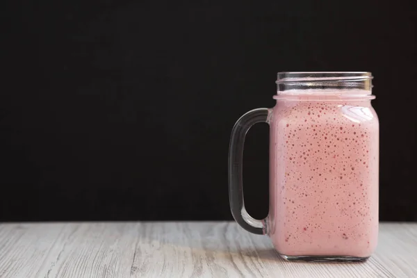 Tasse en verre Mason remplie de smoothie à la banane fraise, côté — Photo