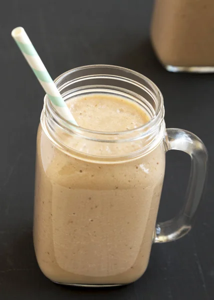 Pisang apel smoothie dalam botol kaca di atas permukaan hitam, sudut rendah — Stok Foto