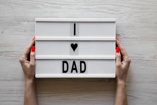 Kobiece ręce trzymać lightbox z "kocham tata" słowa nad białym wo — Zdjęcie stockowe