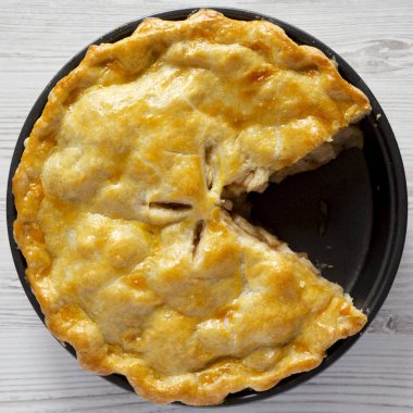 Beyaz ahşap yüzeyüzerinde ev yapımı elmalı turta, üst görünümü. Düz yatıyordu