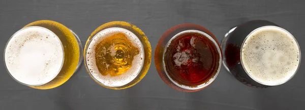 Flight of beers, top view. Black background. Overhead, from abov