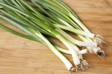 Bambu tahta üzerinde taze yeşil soğan, düşük açı görünümü. Close.