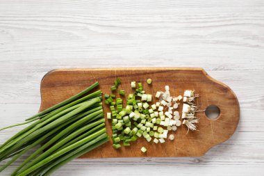 Beyaz ahşap üzerinde rustik ahşap tahta üzerinde doğranmış yeşil soğan 