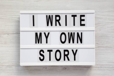 Beyaz ahşap üzerinde modern bir tahta üzerinde ' kendi hikaye ' kelimeleri yazıyorum