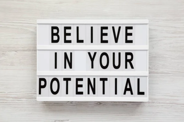 'Cree en tu potencial' palabras en una caja de luz en una madera blanca —  Fotos de Stock