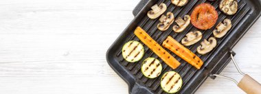 Beyaz ahşap backgroun üzerinde ızgara tavada Izgara sebze