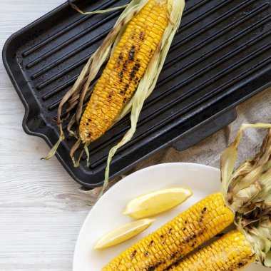 Beyaz ahşap arka plan üzerinde ızgara tatlı mısır, üst görünümü. Summe